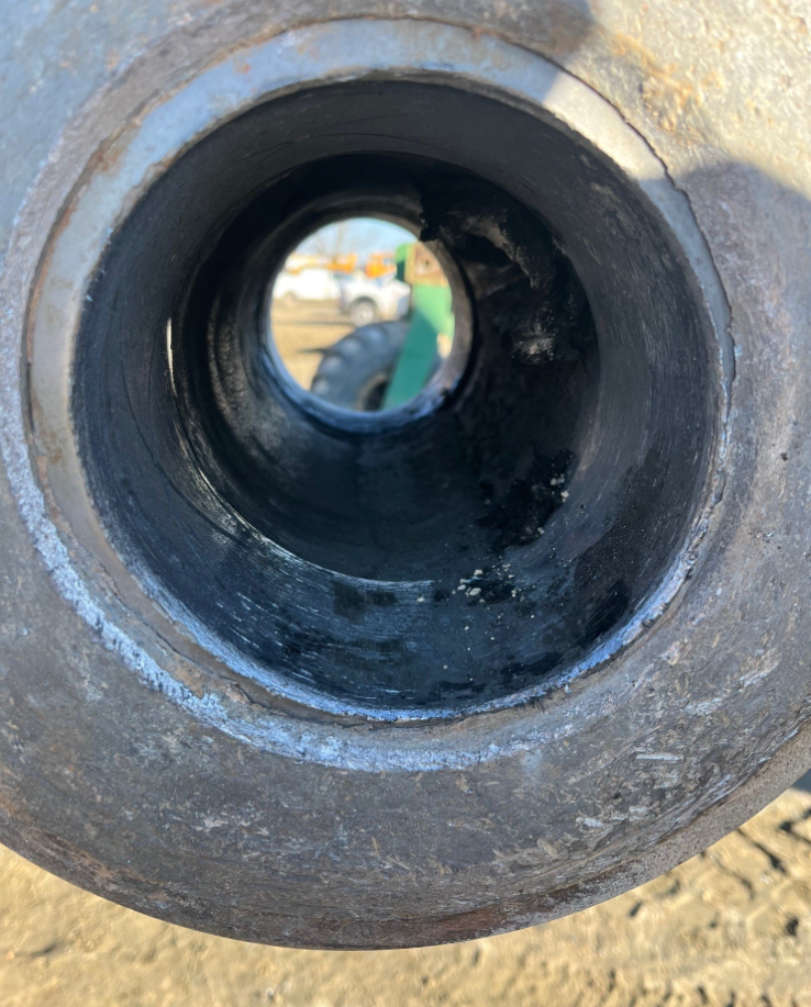 Looking through a large metal tube. The tube is dark inside with a reflection.