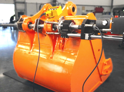 A metal rod being machined by a blue and silver lathe, with metal shavings visible.