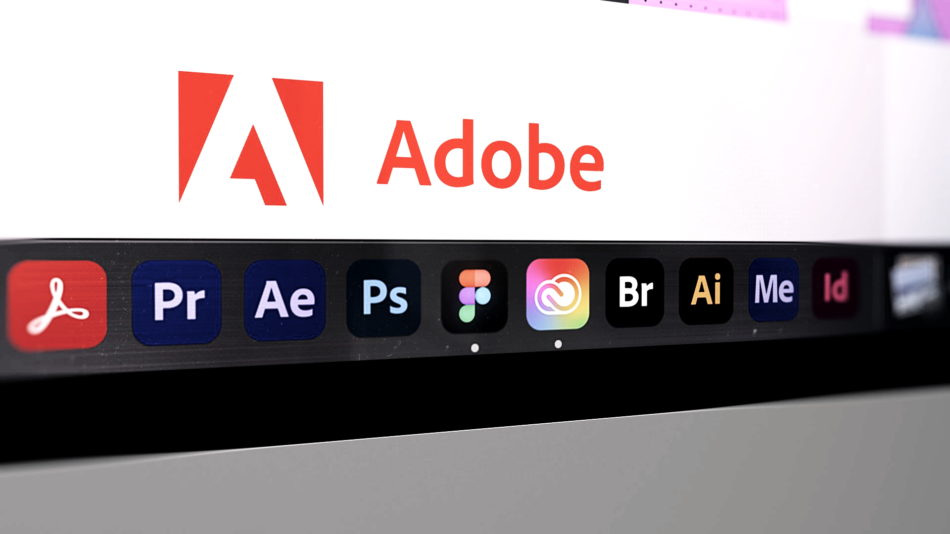 Hands using a keyboard and tablet with a stylus on a white desk; a color palette, plant, and coffee mug are also visible.