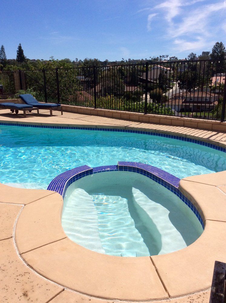 A large swimming pool with a hot tub in the middle