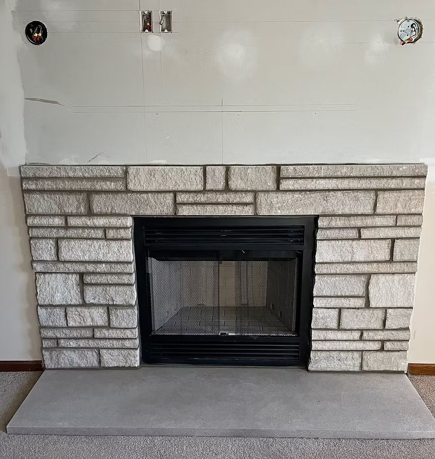 A brick fireplace with a black door in a living room A brick fireplace with a black door in a living room