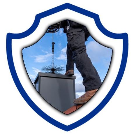 A man is standing on top of a chimney with a shield in the background.