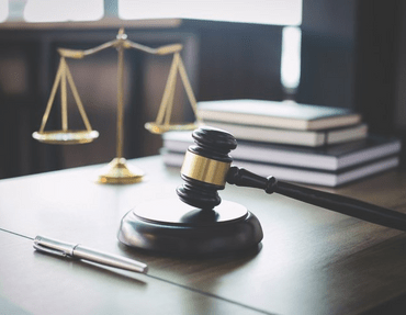 Scales of justice and gavel on wooden table