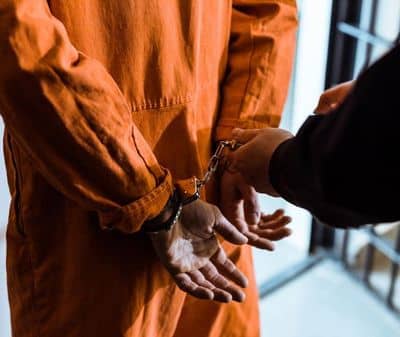 prison officer putting handcuffs on prisoner