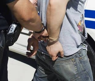 Man being escorted in handcuffs