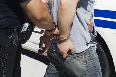 Man being escorted in handcuffs