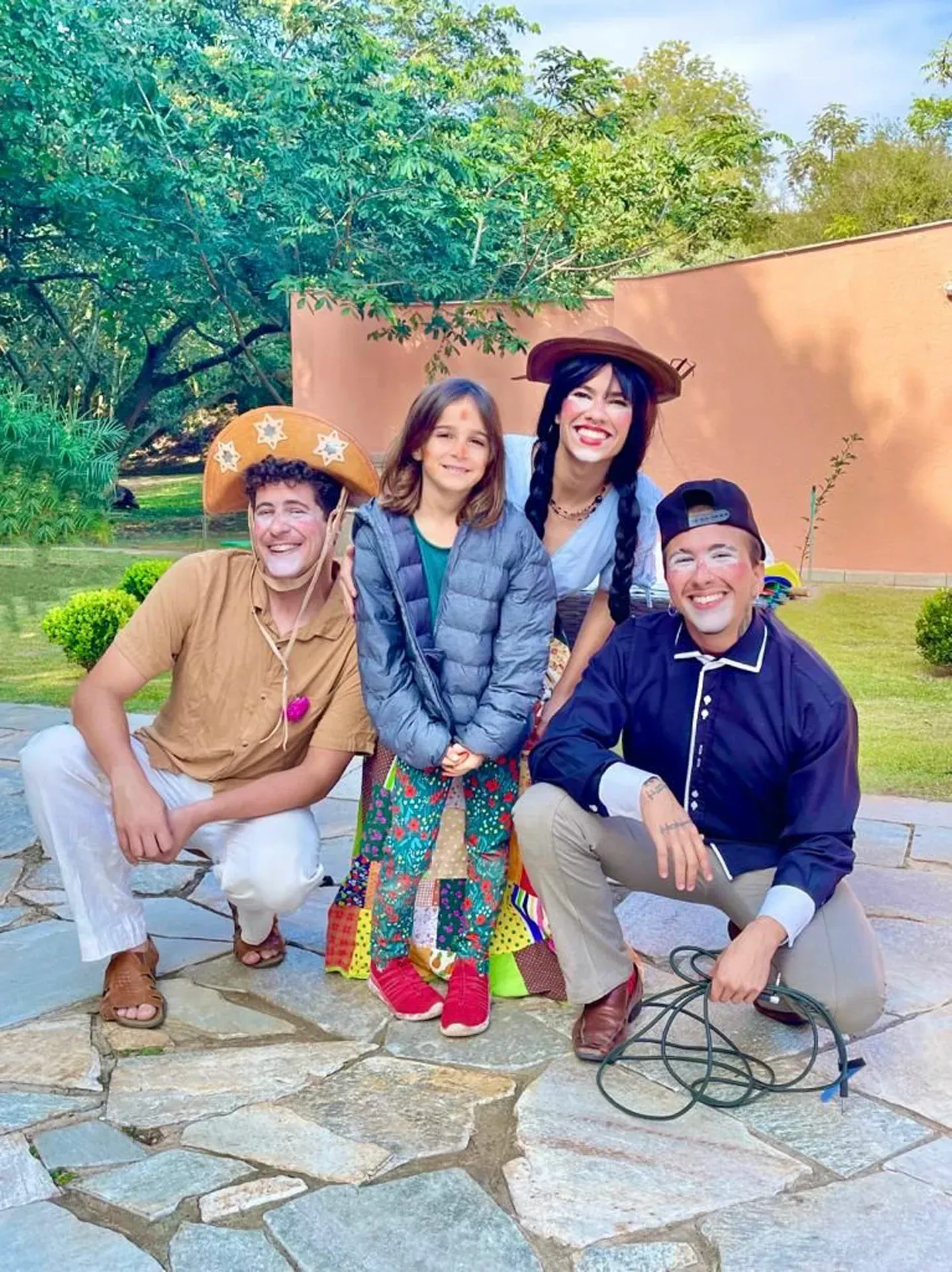 um grupo de pessoas posa para uma foto em uma passarela de pedra.