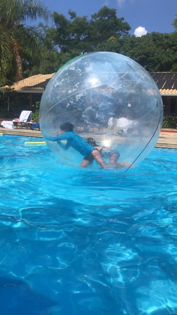 uma pessoa está brincando dentro de uma bolha de água em uma piscina.