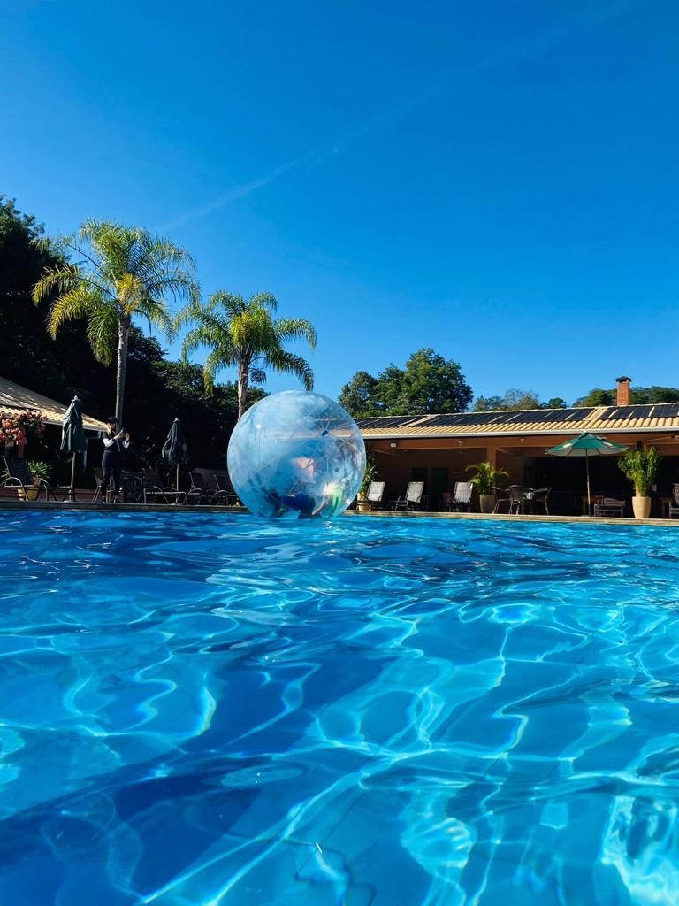 uma pessoa está brincando com uma bola d'água em uma piscina.