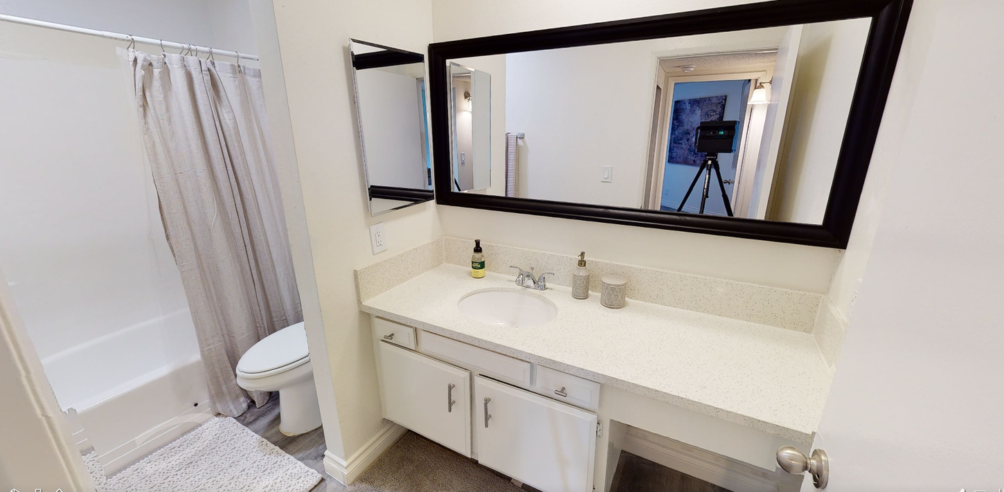 Bathroom with white sink, mirror, and shower curtain.