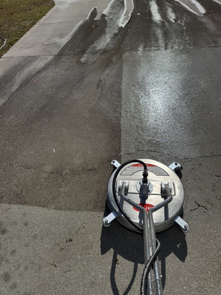 Pressure washer cleaning a concrete surface; one half is clean, the other half is dirty.