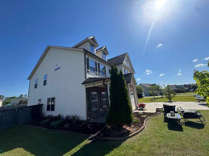 Two-story white house with blue sky, front yard, and landscaping.