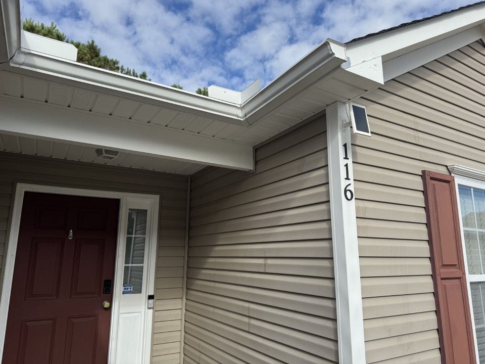 Exterior view of house with brown siding, white trim, and the number 116.