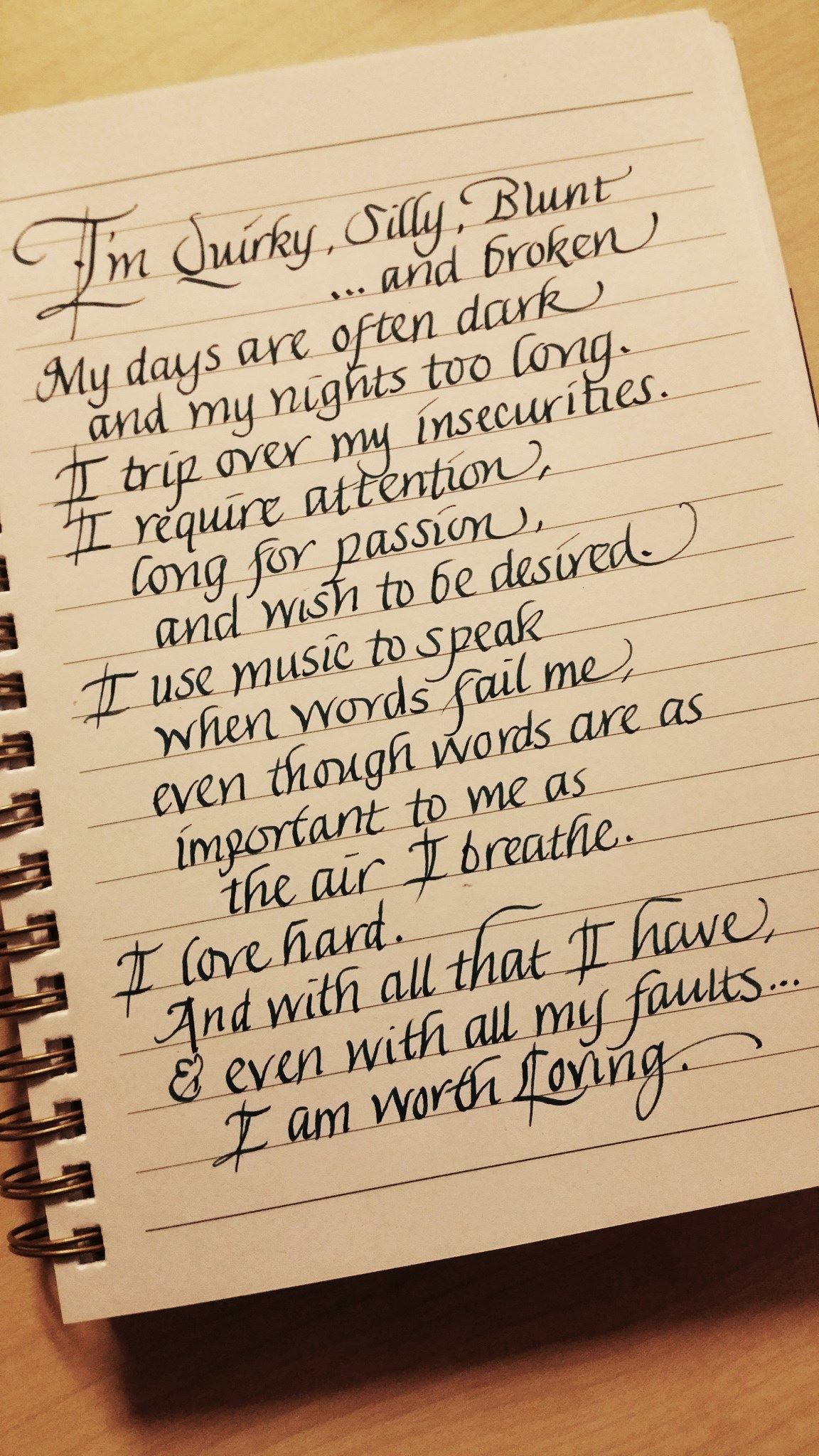 A notebook with a poem written in cursive on it: 