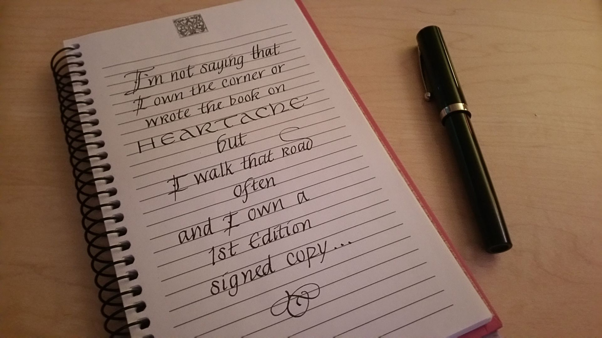 A spiral notebook with a pen on top of it