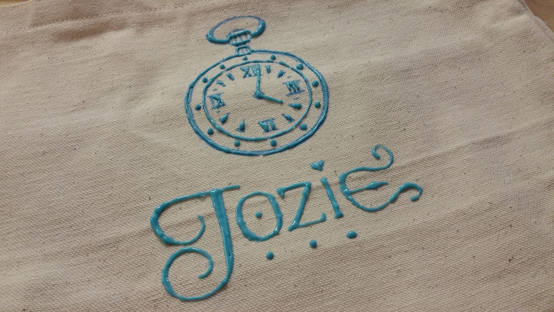 A towel with the name jozie and a pocket watch on it