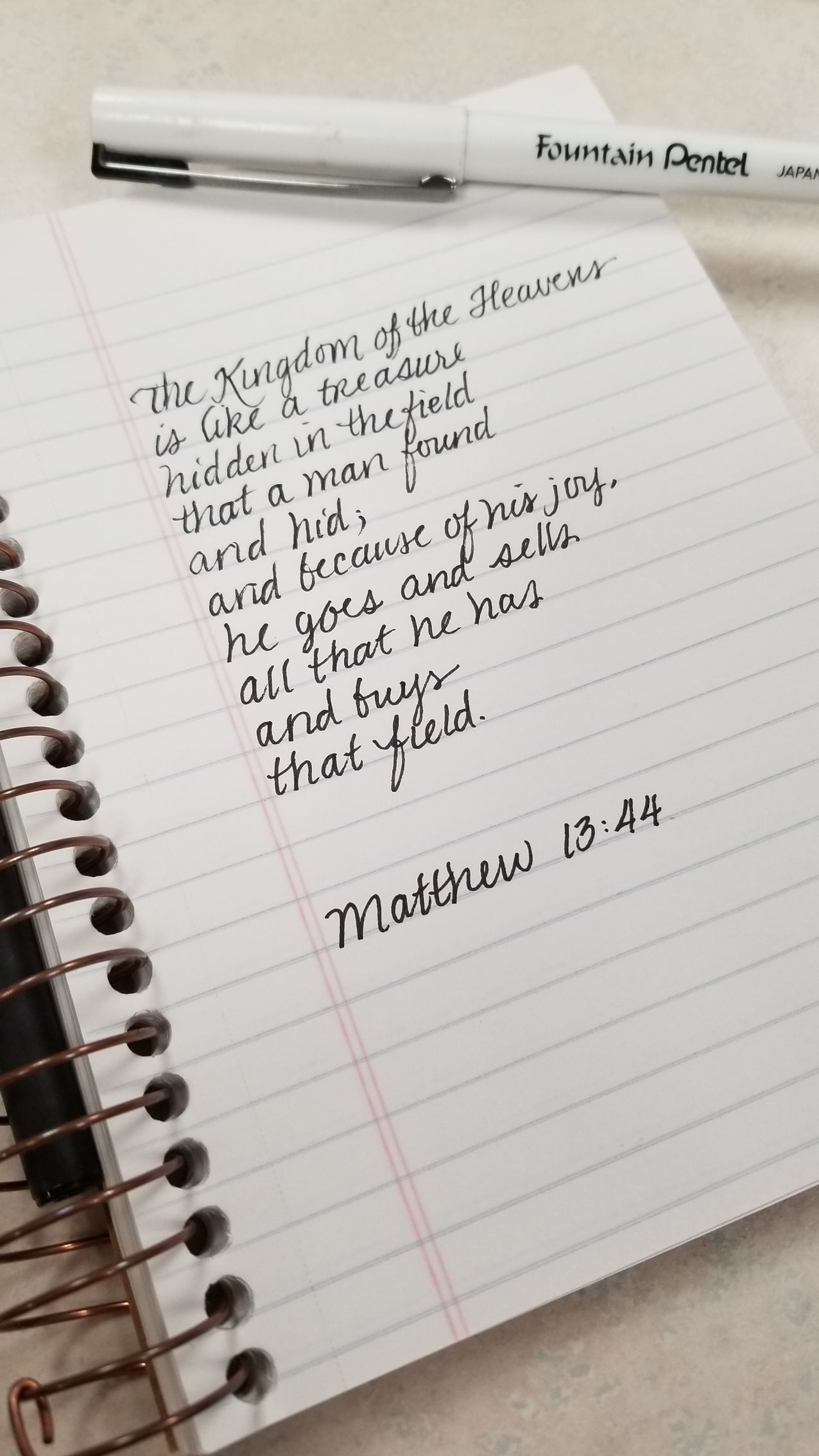 A notebook with a pen and a bible verse on it.