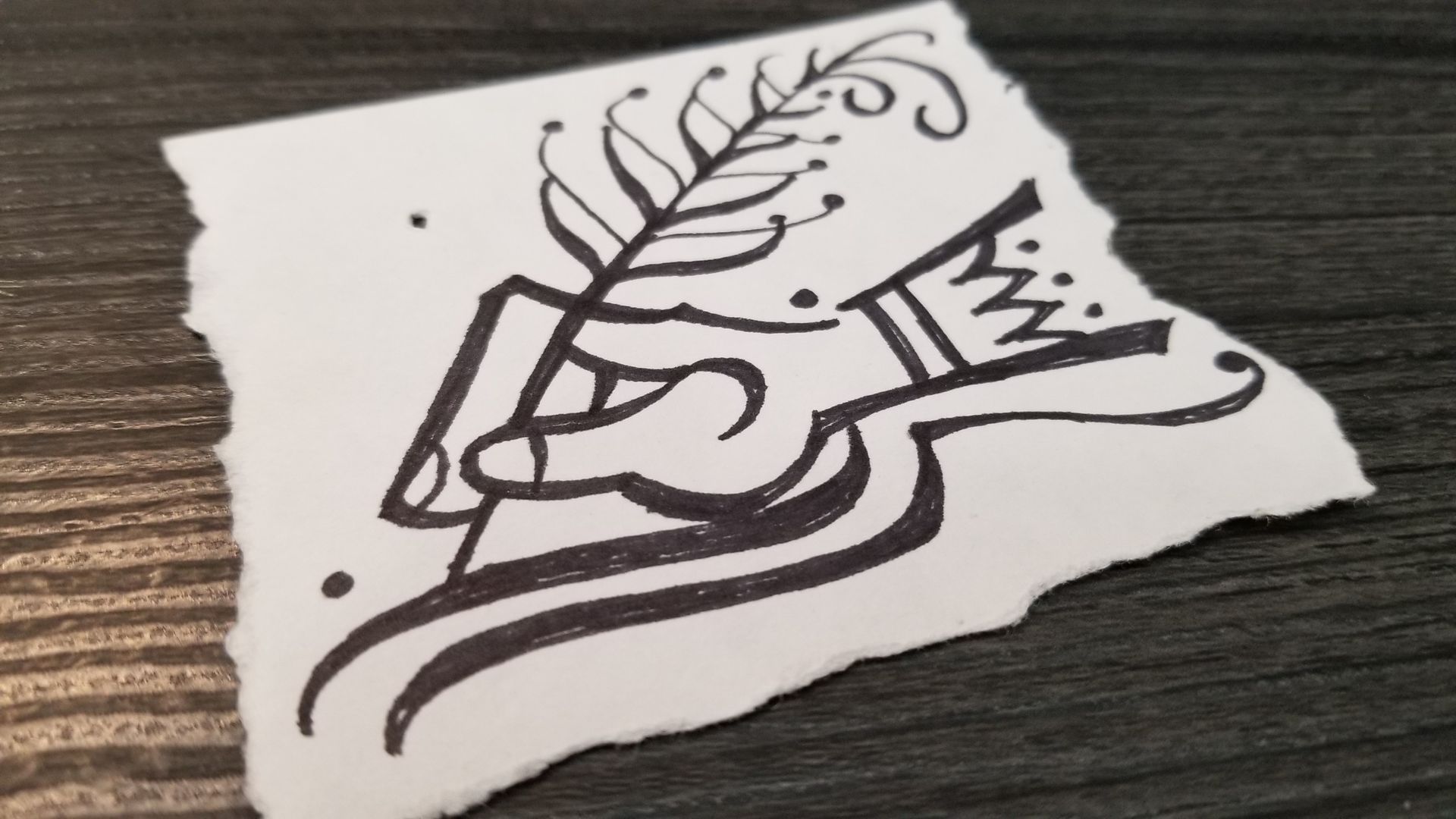 A piece of paper with a drawing of a hand holding a pen