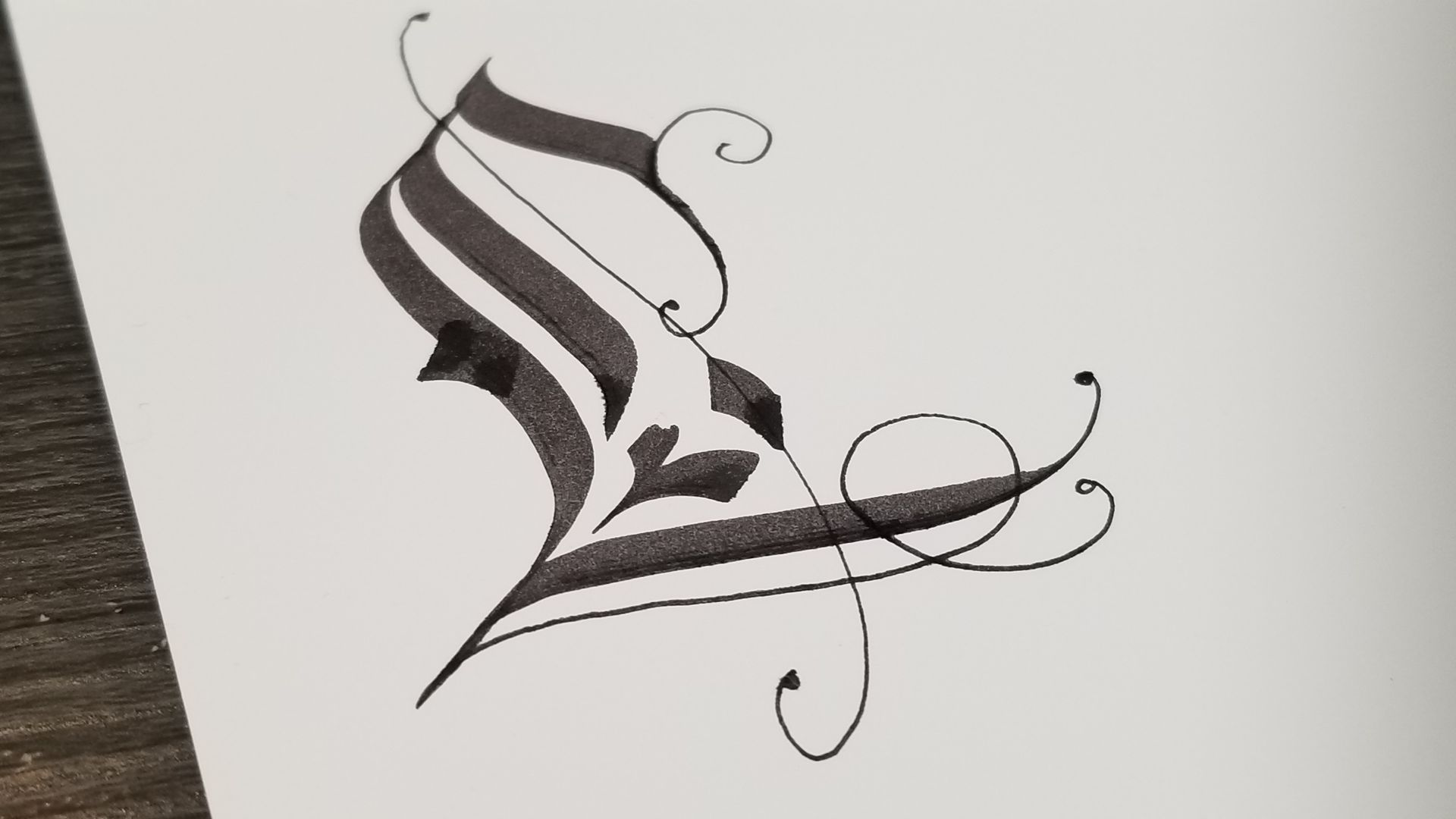 A black and white drawing of a letter l on a piece of paper