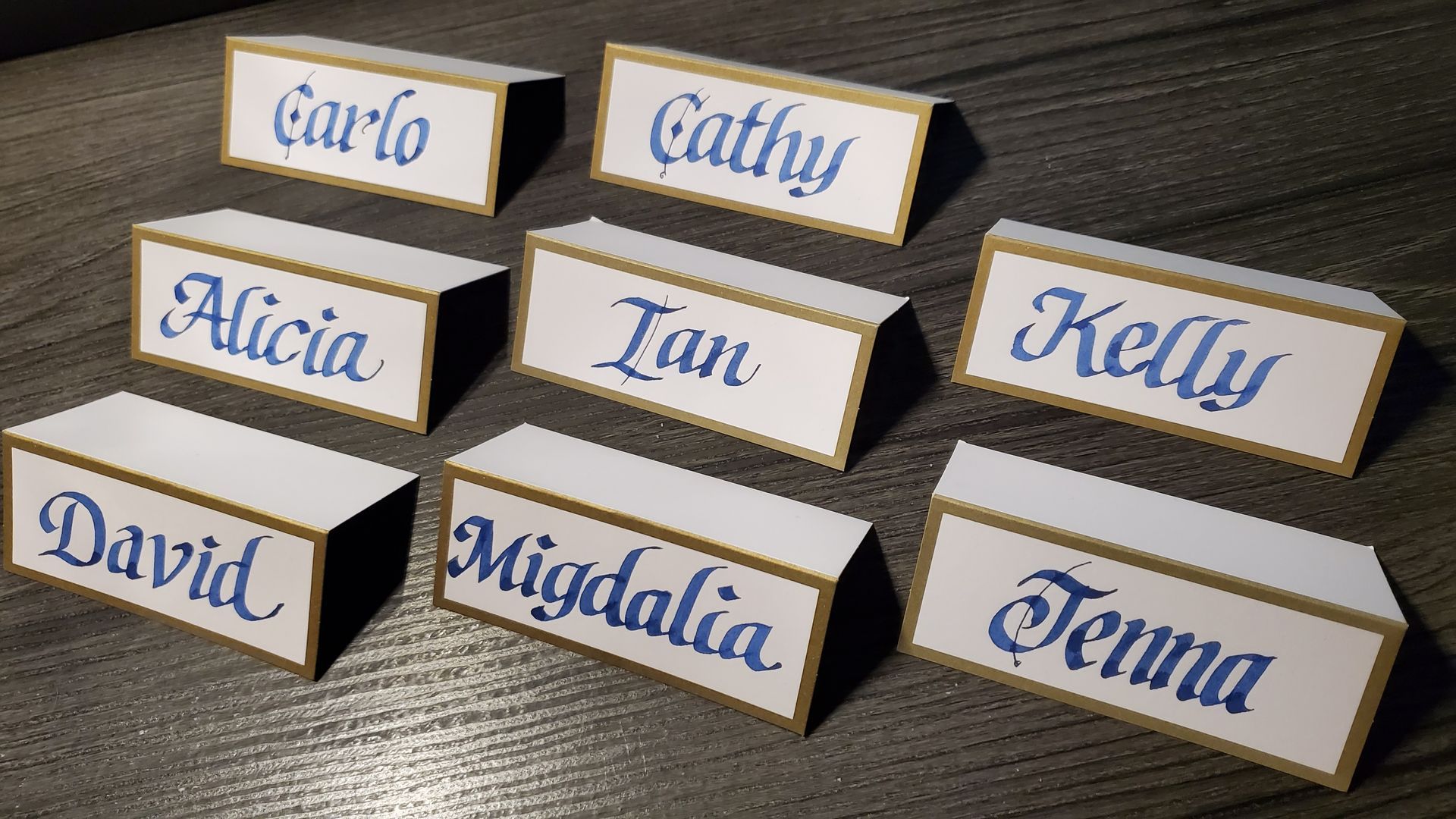 A group of place cards with names on them including carlo cathy alicia tan kelly david migdalia and jenna