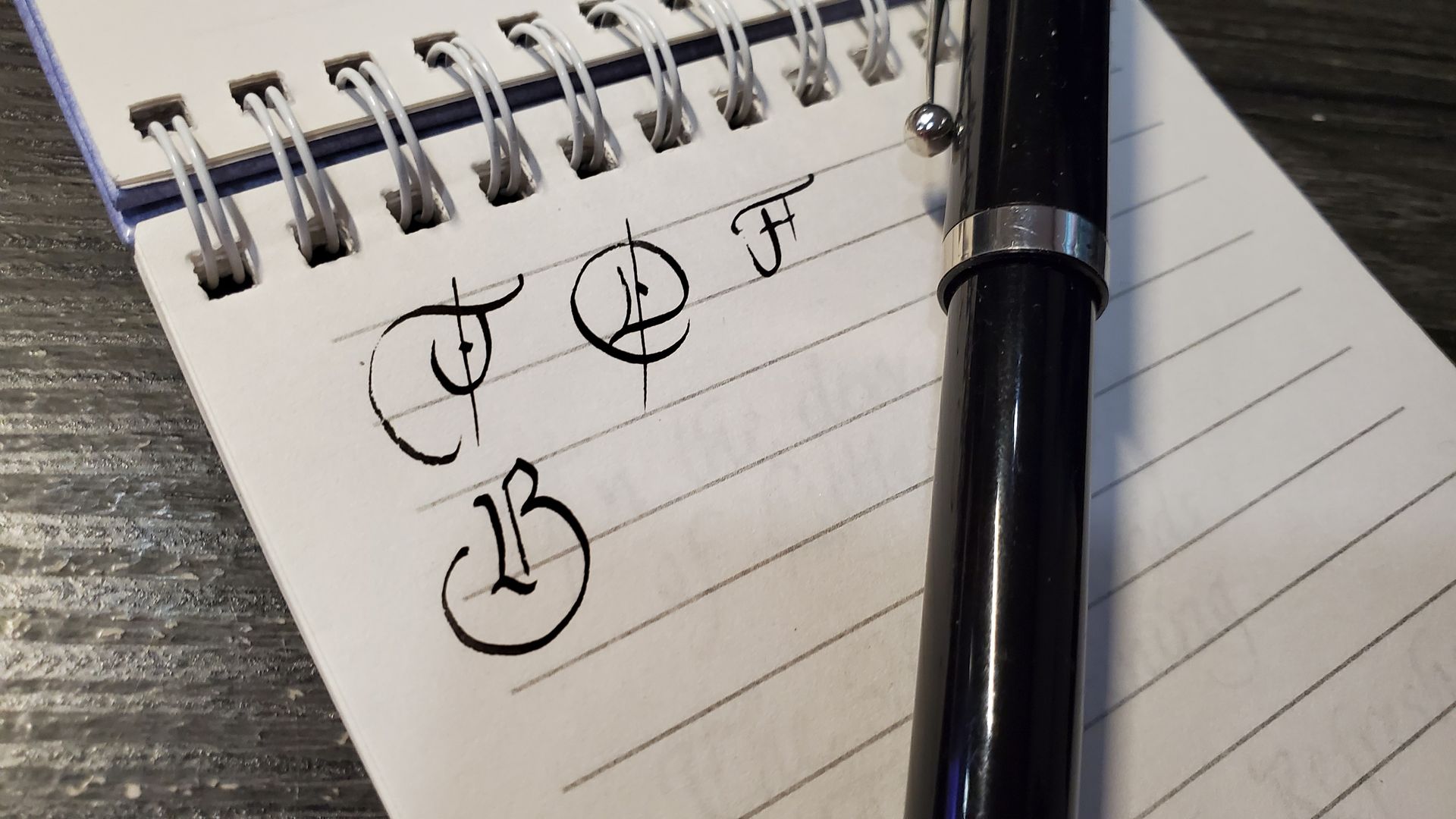 A pen is sitting on top of a notebook with writing on it.