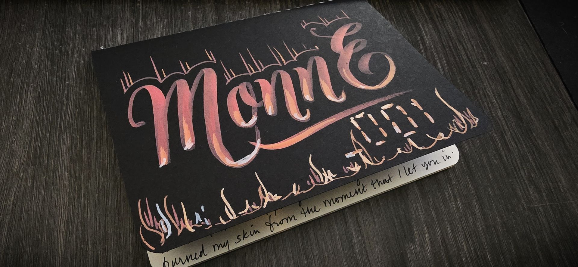 Acrylic chalk paint on matte black journal cover for Twitch user Monn E 001. 