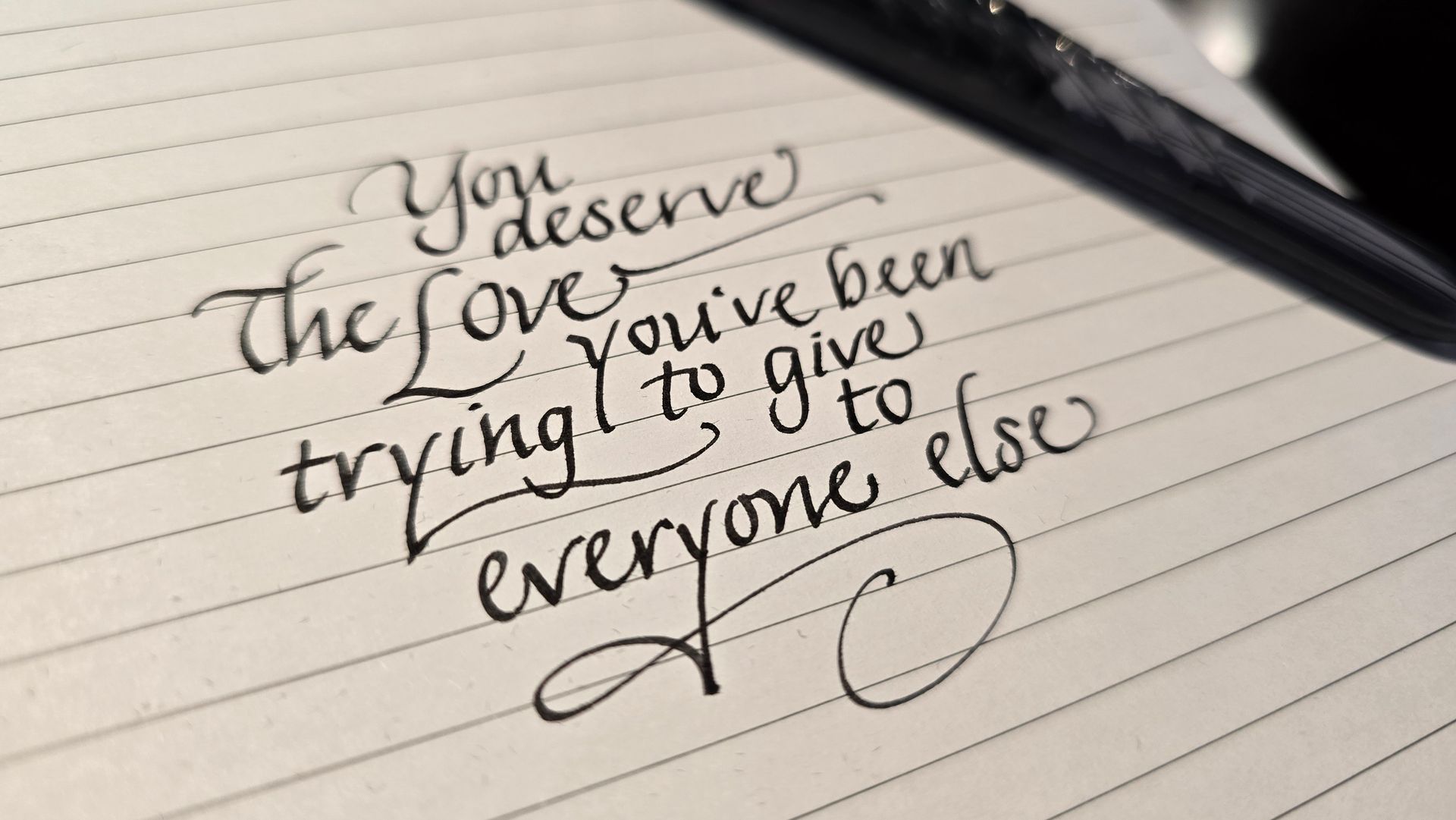 A pen is laying on a piece of paper that says 