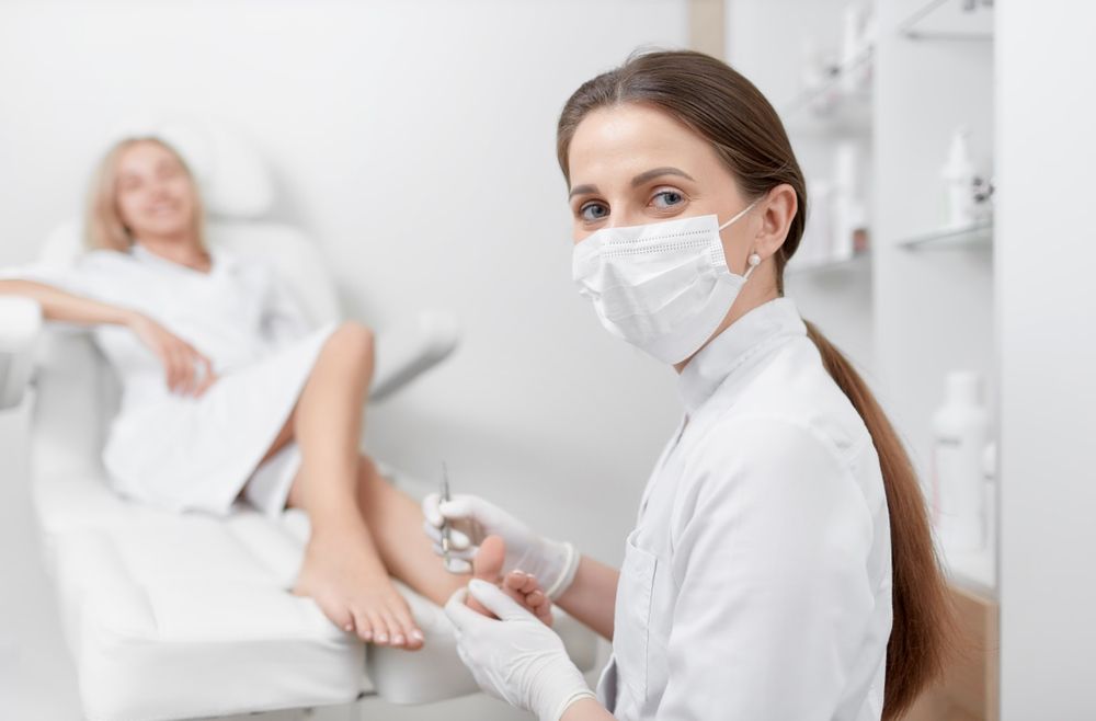 A Woman Is Getting Her Feet Examined By A Doctor While Wearing A Mask And Gloves — Mooloolaba Foot Centre In Mooloolaba, QLD