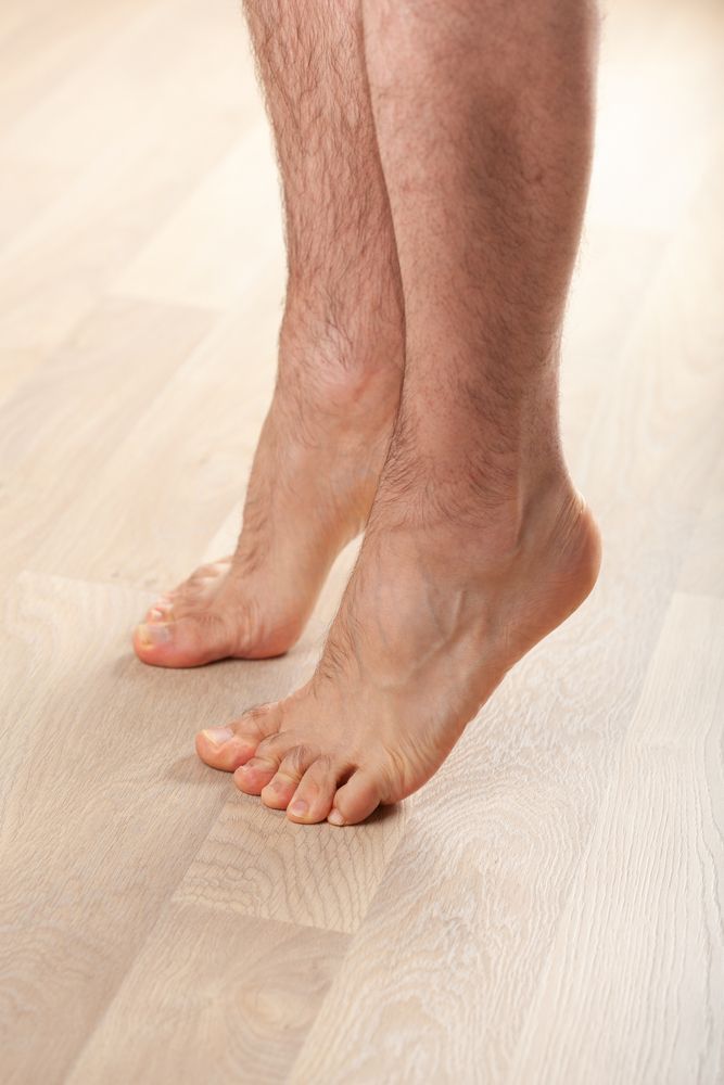 A Man's Bare Feet Are Standing On A Wooden Floor Mooloolaba Foot Centre In Mooloolaba, QLD
