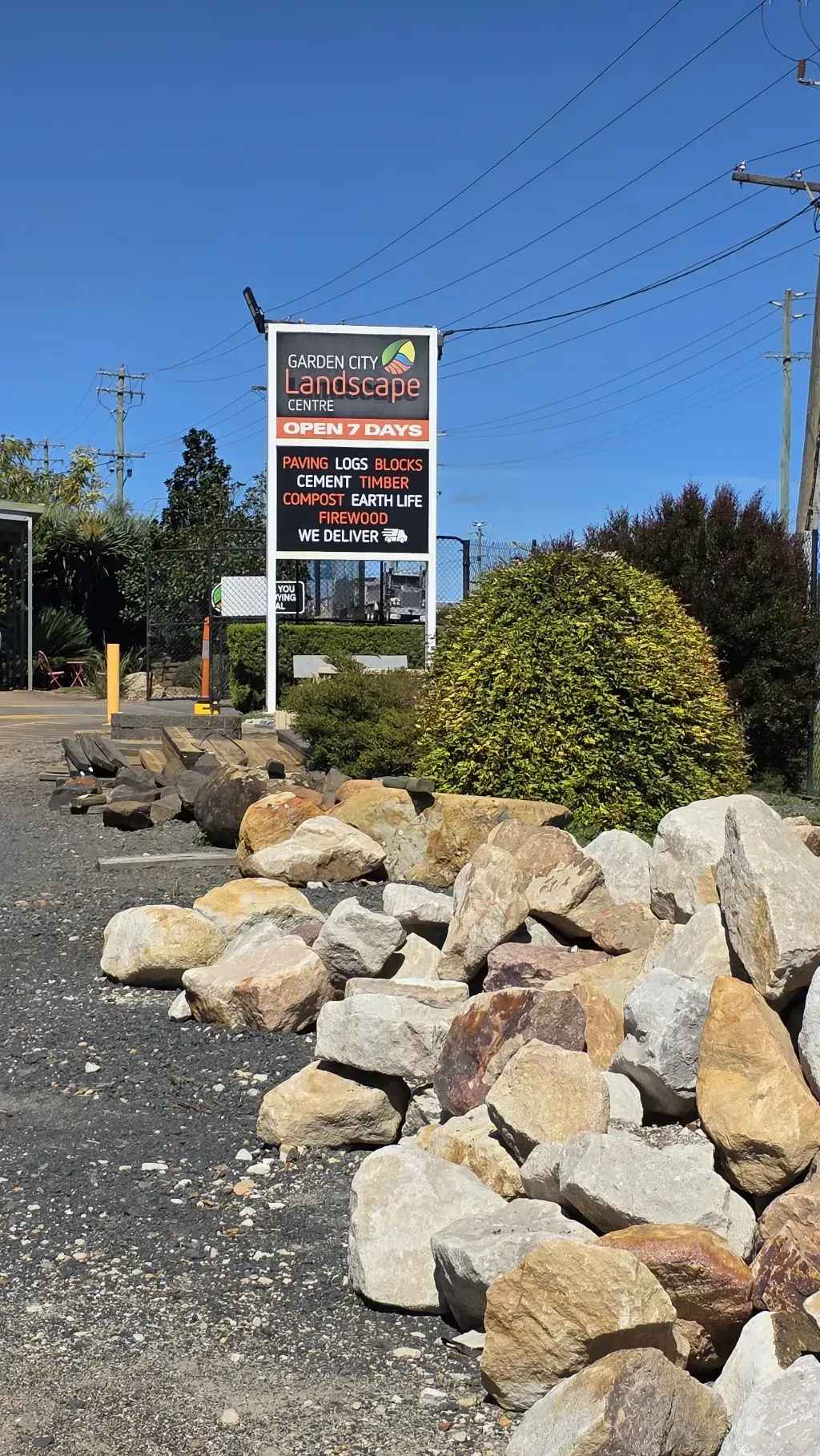 A pile of rocks is sitting on the side of garden city landscape centre next to a sign.