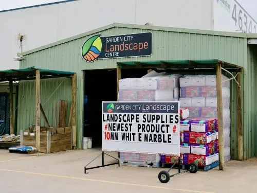 A sign in front of garden city landscape centre that says landscape supplies