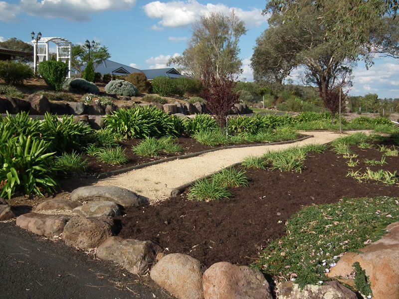 A path in a garden with a house in the background