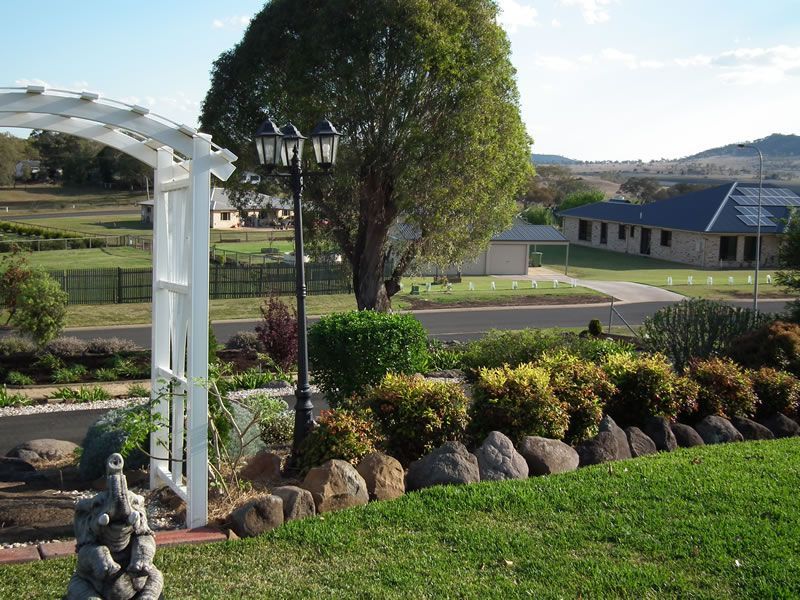 A garden with a white archway and a lamp post