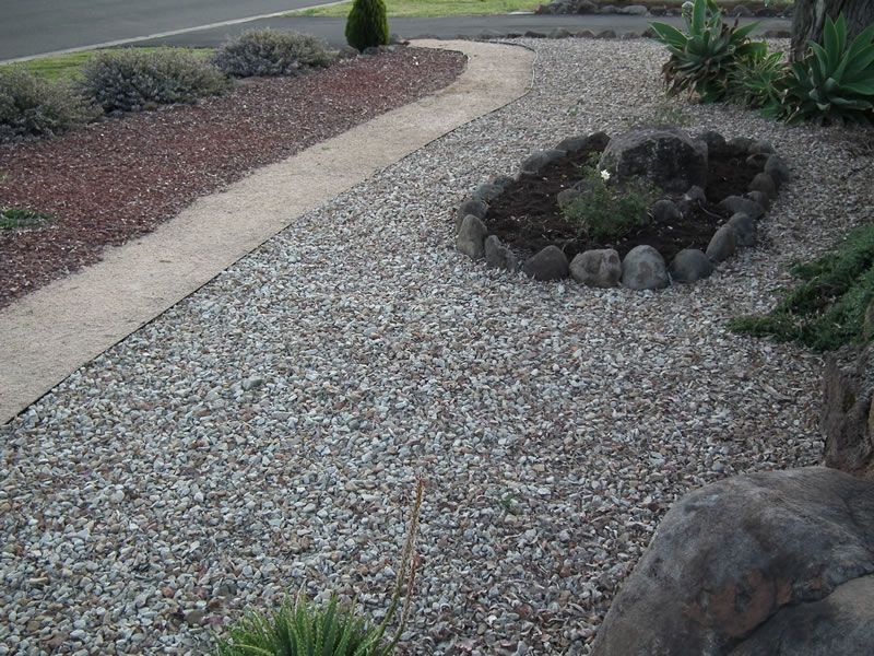 A gravel path with a rock in the middle of it