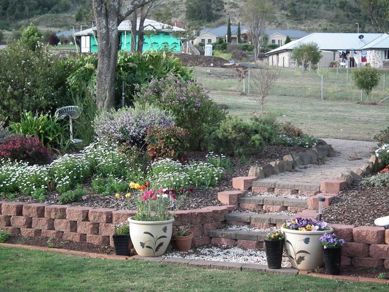A garden with a brick wall and potted plants