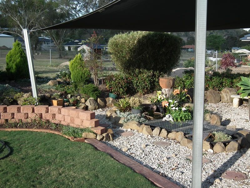 A garden with rocks and plants under an umbrella