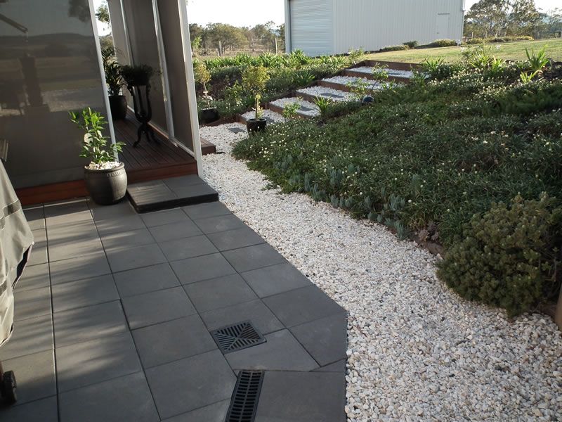 A walkway with gravel and steps leading to a house