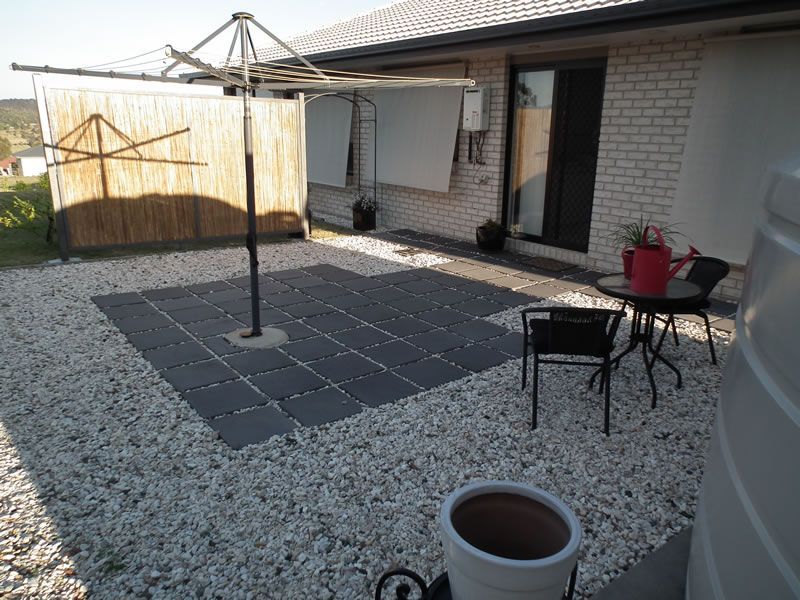 A patio with a table and chairs and a watering can