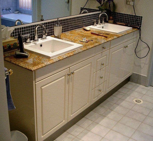 two basins with white cabinets under