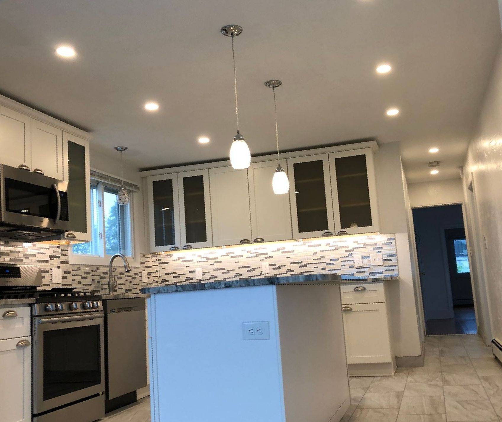 A kitchen with white cabinets and stainless steel appliances