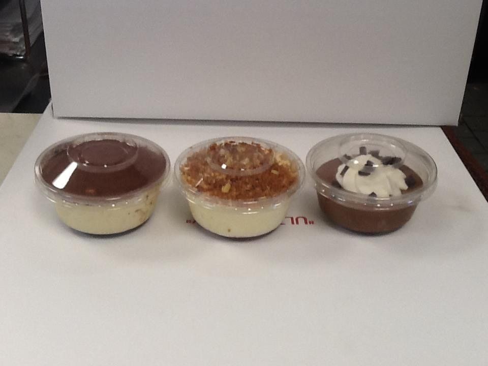 Three different types of desserts in plastic cups on a table