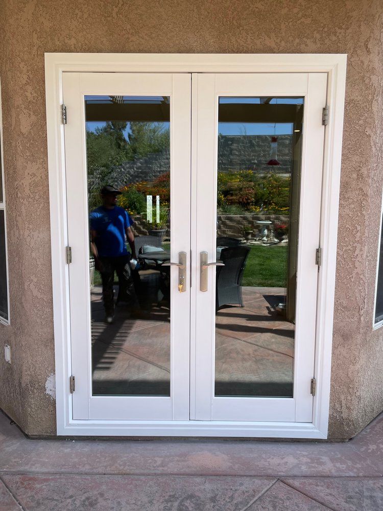 A man in a blue shirt is standing in front of a white door