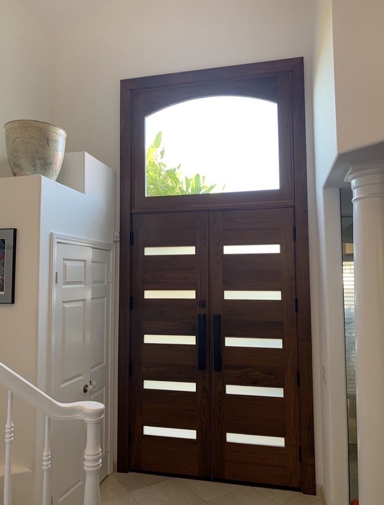 A large wooden door with a window above it