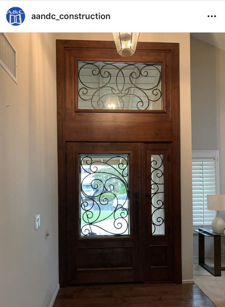 A picture of a wooden door with a wrought iron window in a hallway.