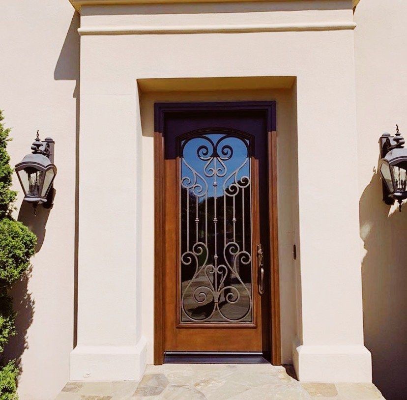 The front door of a house has a wrought iron design on it