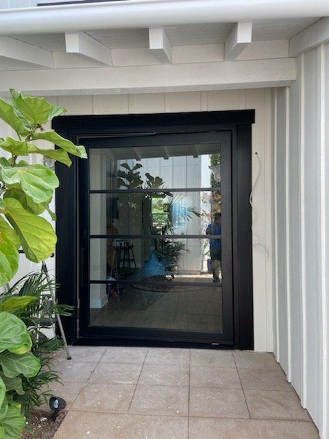 A white house with a black door and a sliding glass door