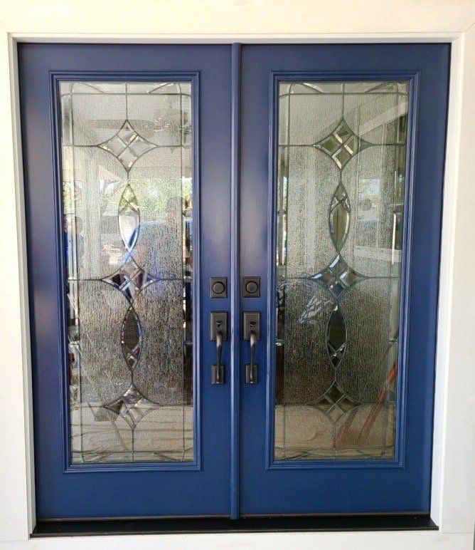 A pair of blue doors with stained glass on them.