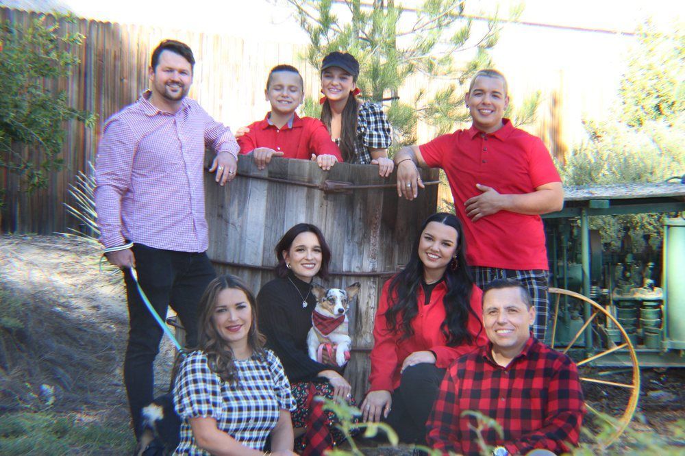 A group of people are posing for a picture in front of a wooden barrel.
