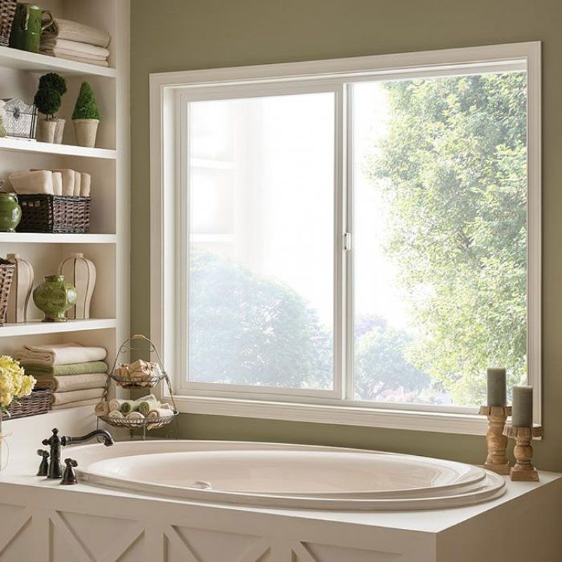 A bathtub in a bathroom next to a window