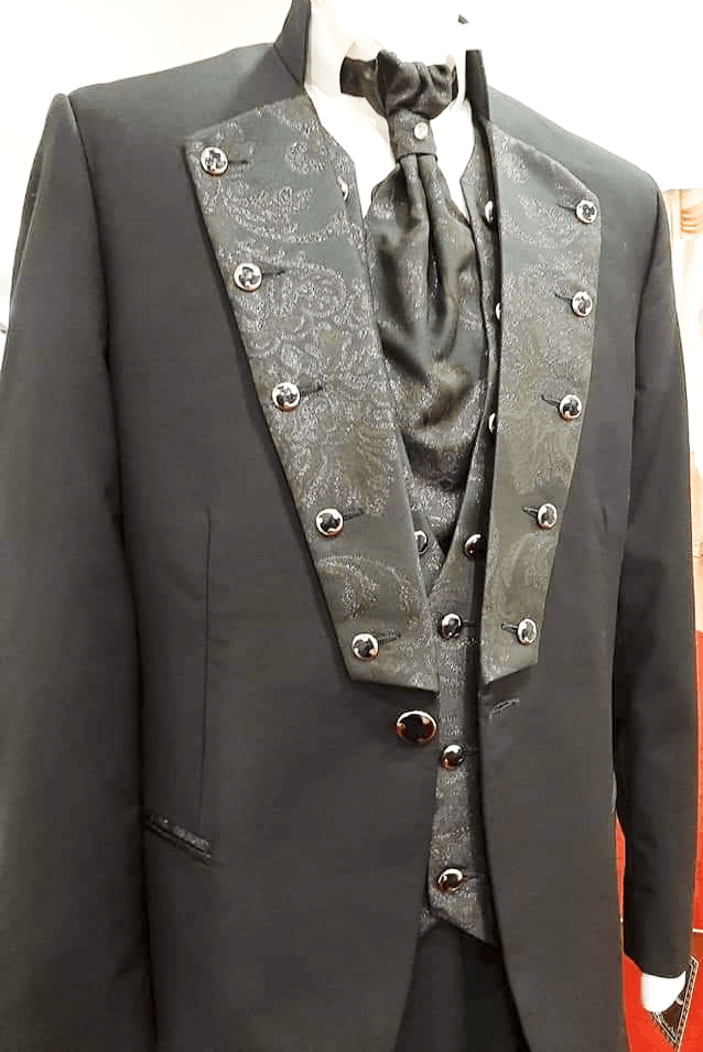 Un uomo indossa uno smoking nero e una cravatta su un manichino.